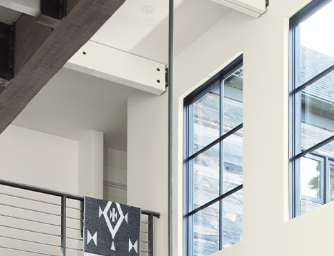 A close up of a building with white walls and black trim, focusing on the high walls above stairs.