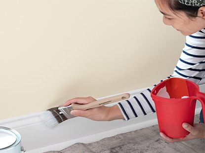Homeowner painting trim and holding the brush properly, using Fresh Start Primer.