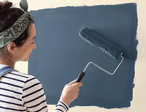 Homeowner painting wall using a quality roller. 