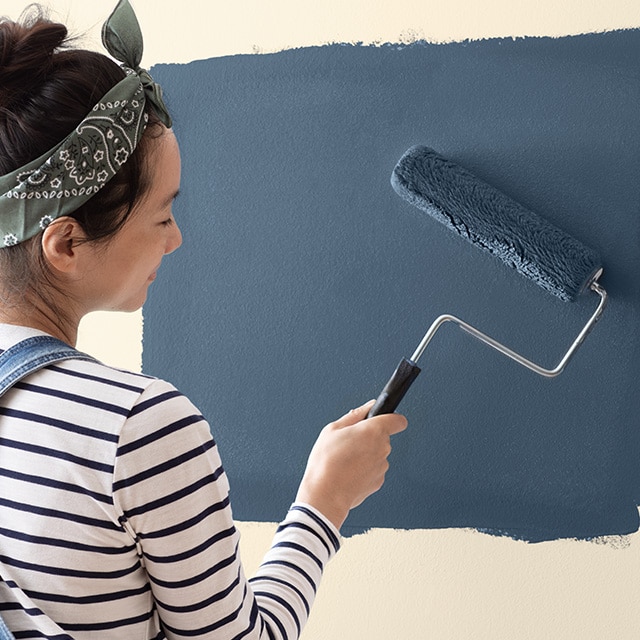 Homeowner painting wall using a quality roller. 