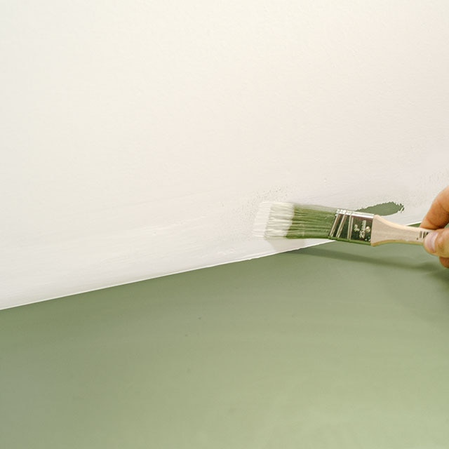 Application de peinture pour corriger une marque de peinture sur un plafond blanc.
