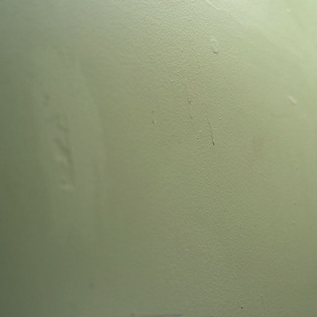 Green paint dripping down a wall.