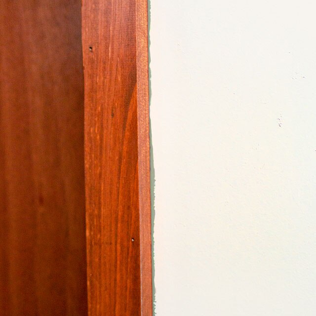 Uneven paint lines between wood edge and white walls.