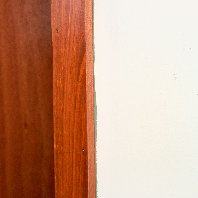 Uneven paint lines between wood edge and white walls. Uneven paint lines between wood edge and white walls.