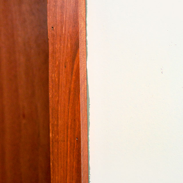  Lignes de peinture inégales entre le bord en bois et les murs blancs.