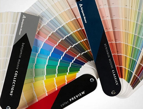 Three open fan decks displaying a range of Benjamin Moore Colour Collections.