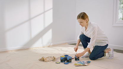 Une femme ouvre des contenants de peinture
