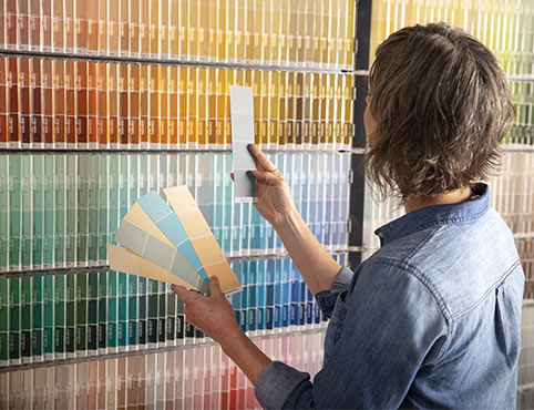 Mujer inspeccionando varias muestras de pintura.