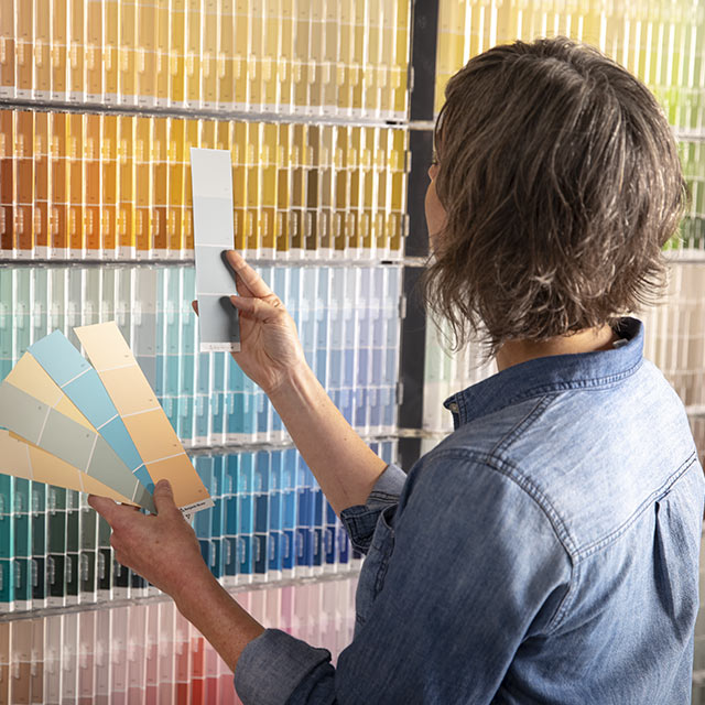 Woman inspecting various paint swatches.