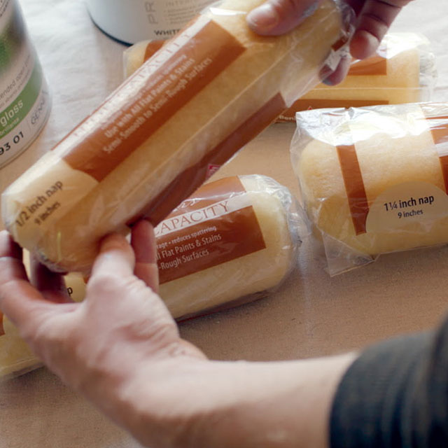 A homeowner removing a roller cover from its packaging.