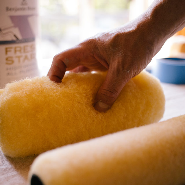 A homeowner picking up a roller cover to start their painting project.