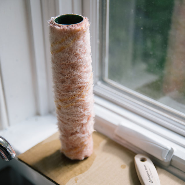 A roller cover on a windowsill, drying in the sun.