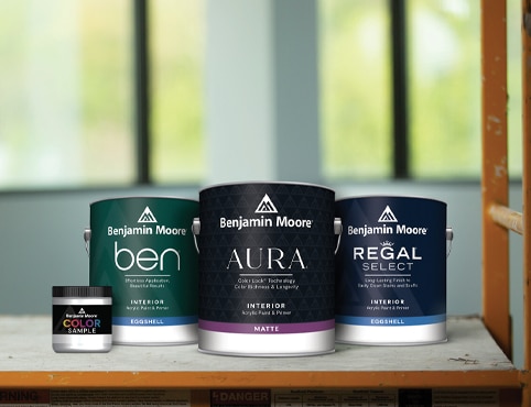 An 8 oz. paint color sample next to a gallon of Ben Interior, a gallon of Aura Interior, and a gallon of Regal Select Interior.