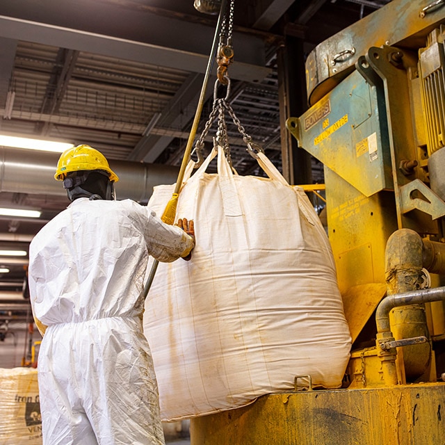 Benjamin Moore employees working with raw materials in a Benjamin Moore warehouse.