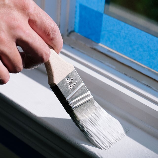 A homeowner priming their window trim.