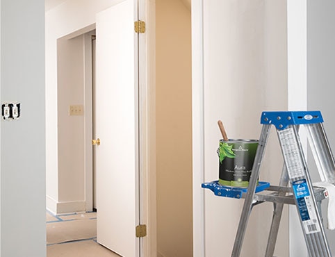 Contenant ouvert de peinture bleue Benjamin Moore et pinceau.