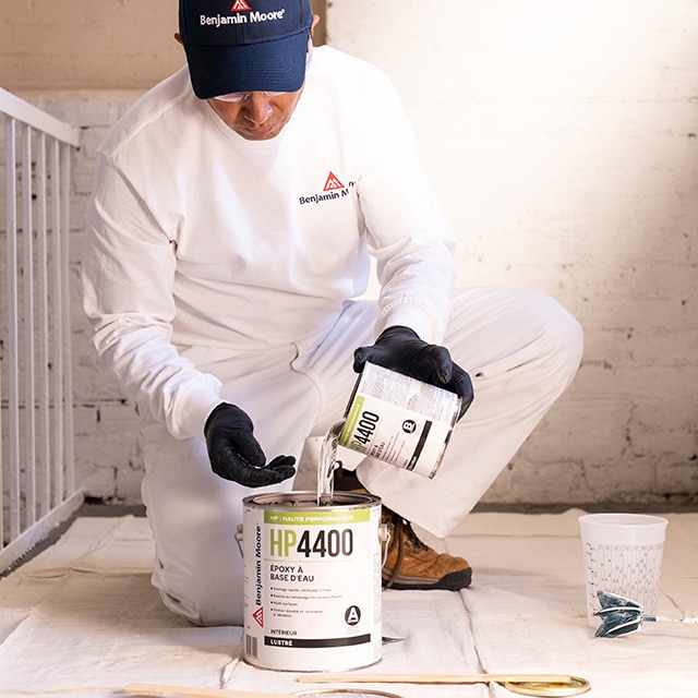 Une personne combine les deux composants de l’époxy à base d’eau HP4400, en versant le contenu du petit contenant dans le contenant de 3,78 L.