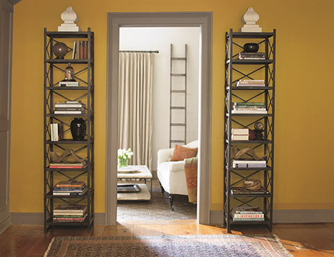 Yellow walls with a gray trim hallway frame leading to a white cozy living room.