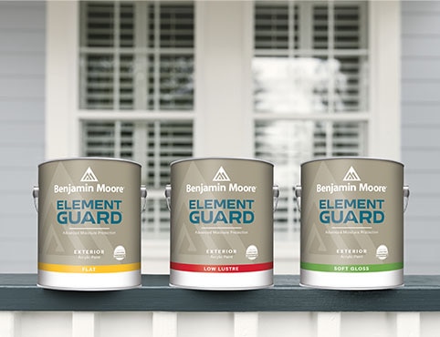 Three gallons of Element Guard® exterior paint sitting on a blue and white porch railing, in front of a window.