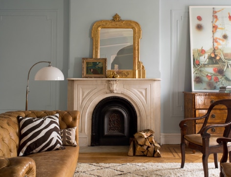 Light blue living room with crown molding and elegant fireplace