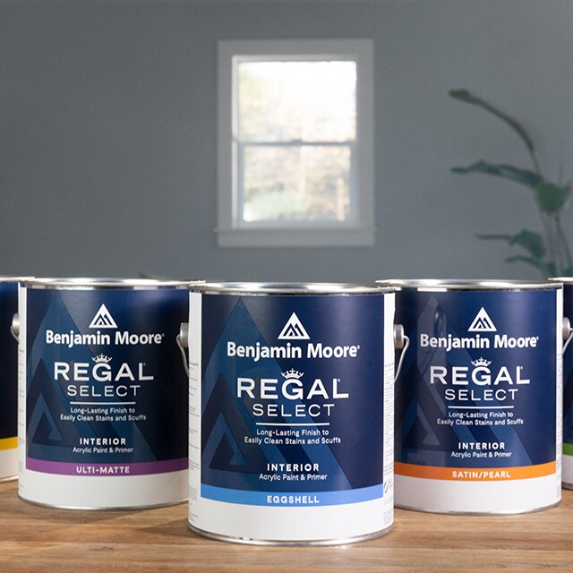 Cans of Regal Select Interior Paint on a wood tabletop.