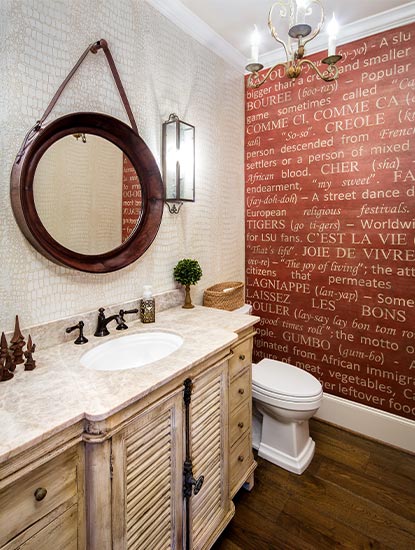 Un hermoso baño con una audaz pared de acento rojo con el diccionario cajún estampado en ella.