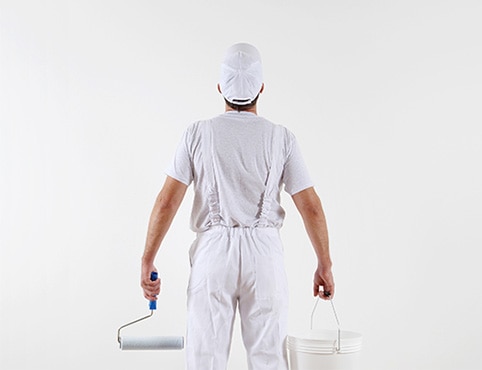 Painting contractor assessing a white wall. Painting contractor assessing a white wall.