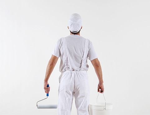 Painting contractor assessing a white wall.