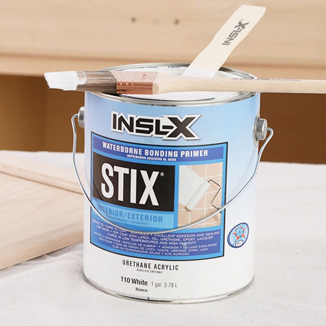Contenant de STIX d'INSLX sur un chantier avec pinceau et bâton à mélanger