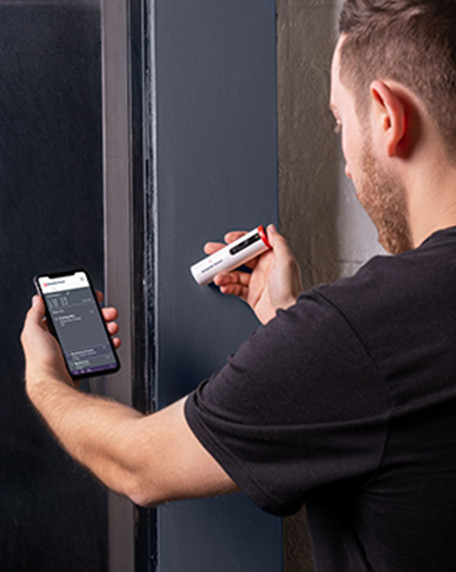 Un entrepreneur apparie une couleur sur un mur à l’aide de l’appareil ColorReader Pro de Benjamin Moore Un entrepreneur apparie une couleur sur un mur à l’aide de l’appareil ColorReader Pro de Benjamin Moore