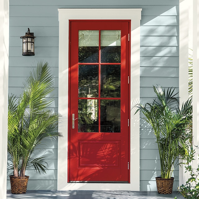 A welcoming front entrance with a red-painted door and potted plants