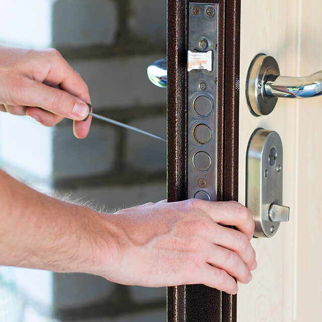 A painting contractor removes door hardware at the customer’s home