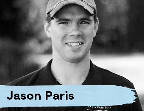 A young man wearing a baseball hat and a black polo shirt labeled 