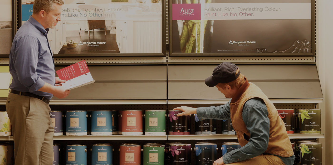 A store owner helps a paint contractor choose the best Benjamin Moore product.