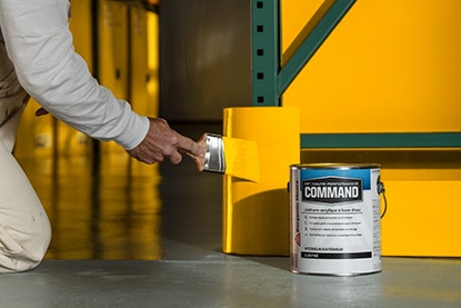 Une personne à genoux applique au pinceau de la peinture orange sur une partie de mur derrière un contenant de 3,79 L d’uréthane acrylique à base d’eau Command de Benjamin Moore. Une personne à genoux applique au pinceau de la peinture orange sur une partie de mur derrière un contenant de 3,79 L d’uréthane acrylique à base d’eau Command de Benjamin Moore.