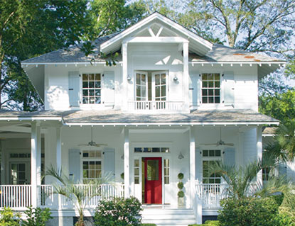 Traditional home with red door and wrap-around porch