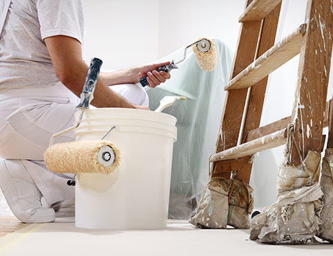 A Benjamin Moore contractor paints a white wall. A Benjamin Moore contractor paints a white wall.
