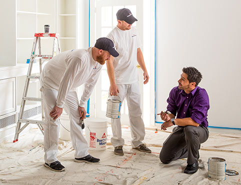 A group of contractors get advice from a Benjamin Moore sales rep. A group of contractors get advice from a Benjamin Moore sales rep.