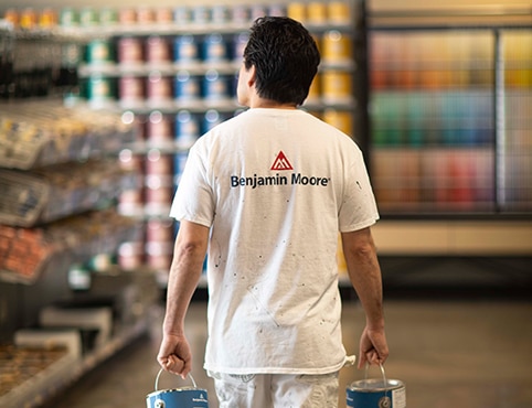 A painting contractor carries cans of premium paint through a Benjamin Moore® independent retailer. 