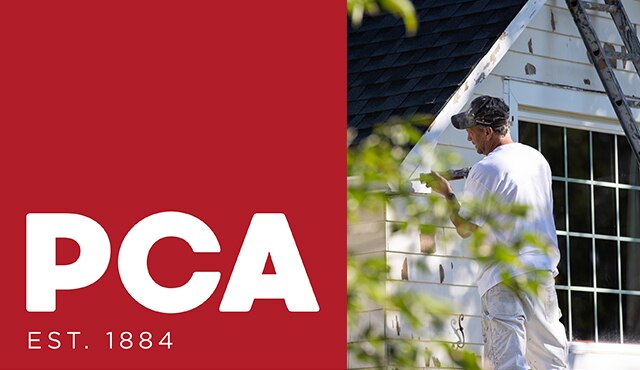 A painting contractor using a caulking gun on the exterior of a white painted house.