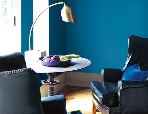 Mur d’un bleu vif avec fauteuils en cuir et table circulaire Mur d’un bleu vif avec fauteuils en cuir et table circulaire