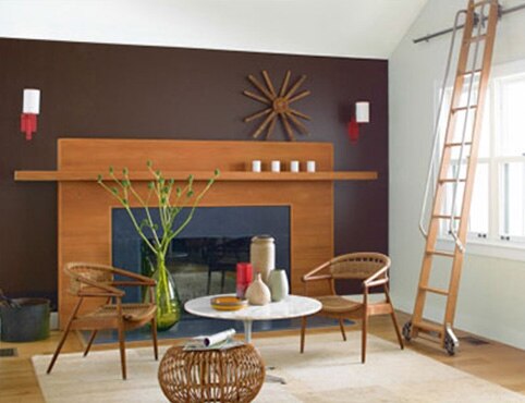 Living room with wide fireplace, purple wall and rolling ladder