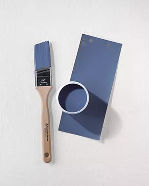 Una brocha, una muestra de pintura y una paleta de colores de Azul de Nova