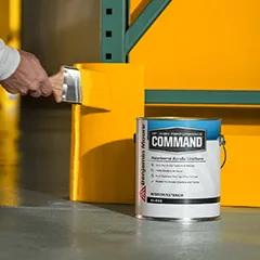 Miniatura: Una persona pintando con brocha una sección de pared de color naranja detrás de una lata de 1 galón de Command® Uretano acrílico al agua de Benjamin Moore.