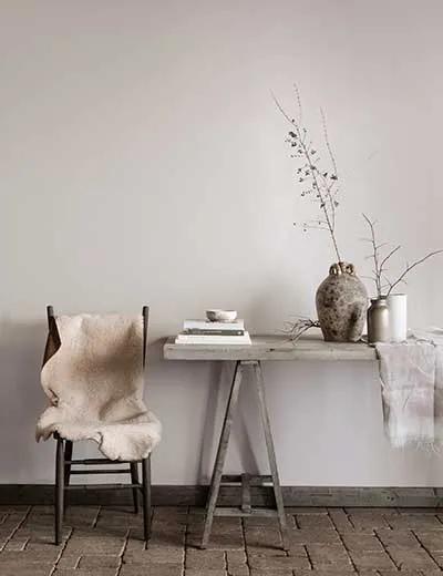 Una pared pintada de beige con una mesa delante.