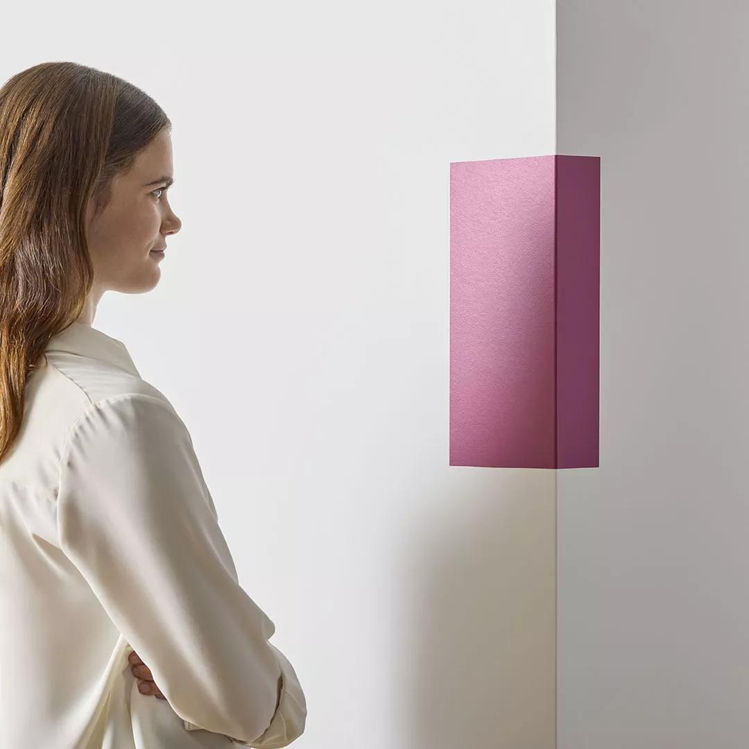 Mujer probando una muestra autoadhesiva de pintura de 9" x 14.75" en la esquina de una pared