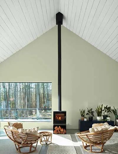 Una habitación pintada de verde pálido con techo traslapado blanco.